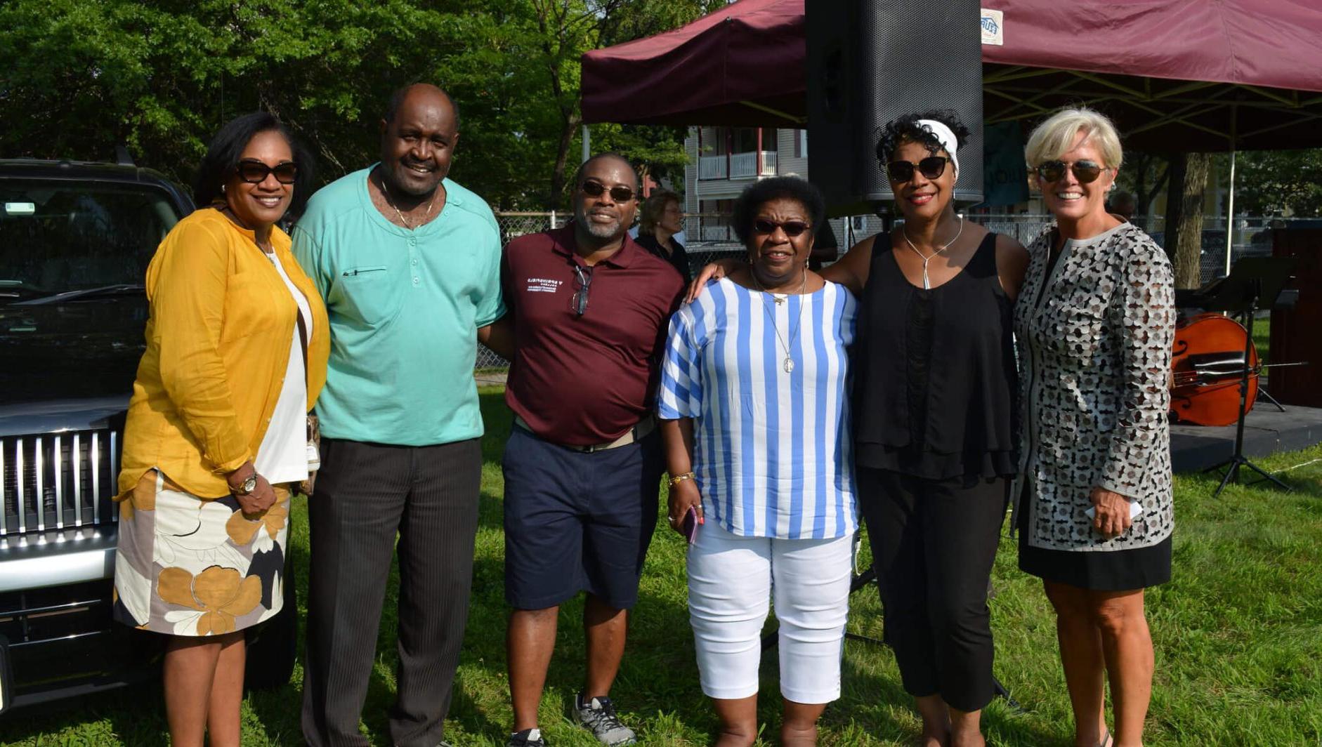 Group of staff stand around at block party. 