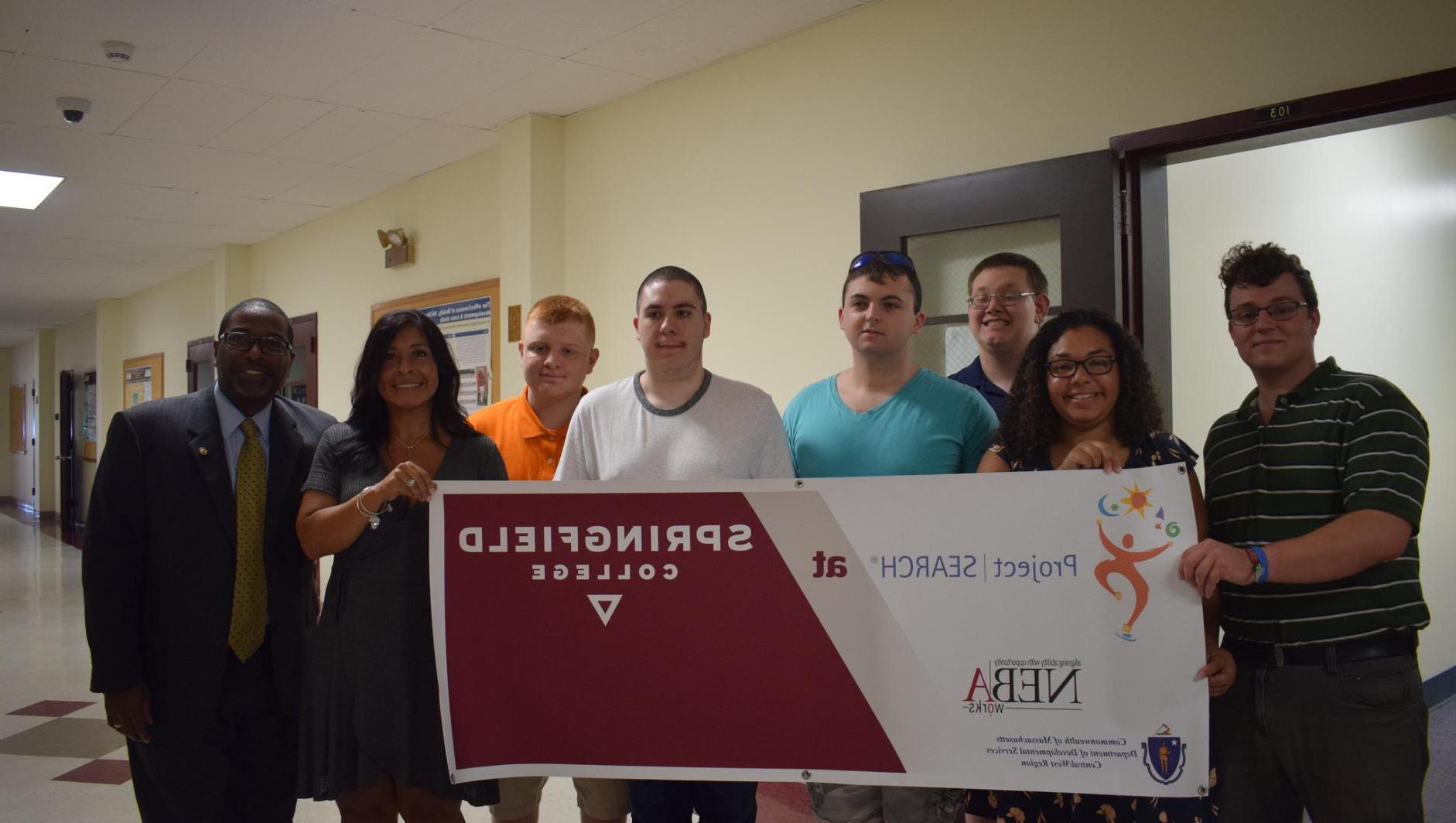 Project Search participants and staff stand with the banner. 