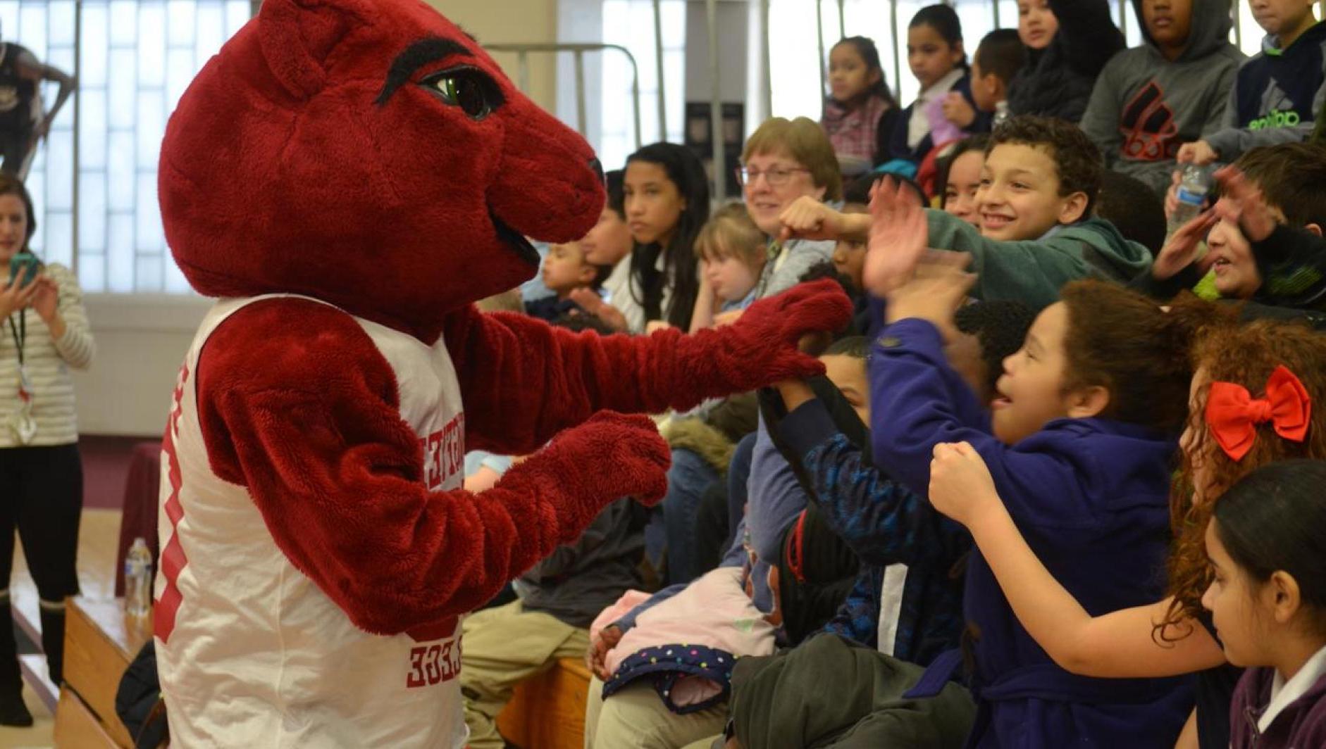 Local students high five Pride at a basketball game. 