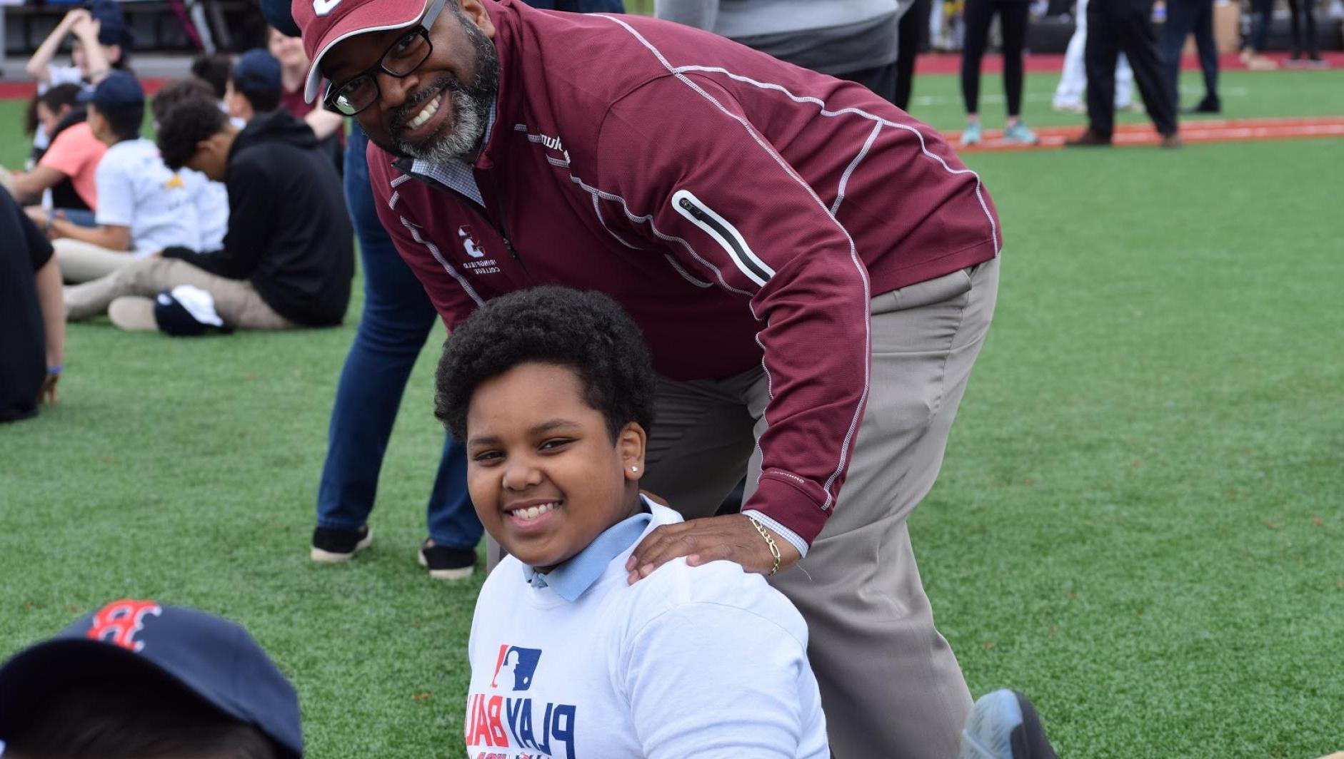 Calvin Hill poses with a participant during Play Ball event. 